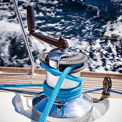 Winch with rope and crank on sailing boat.